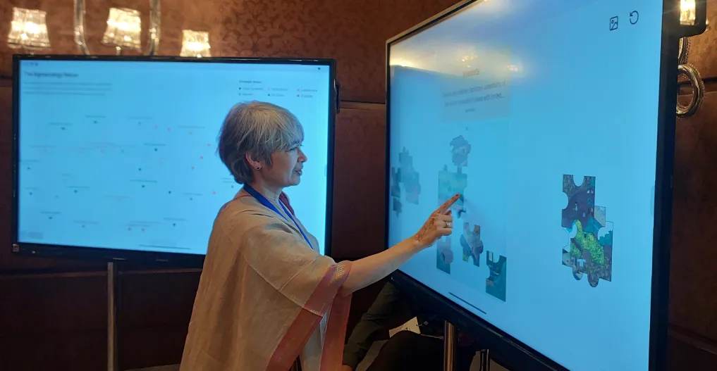 An attendee engaging with the digital puzzle on a large TV screen.
