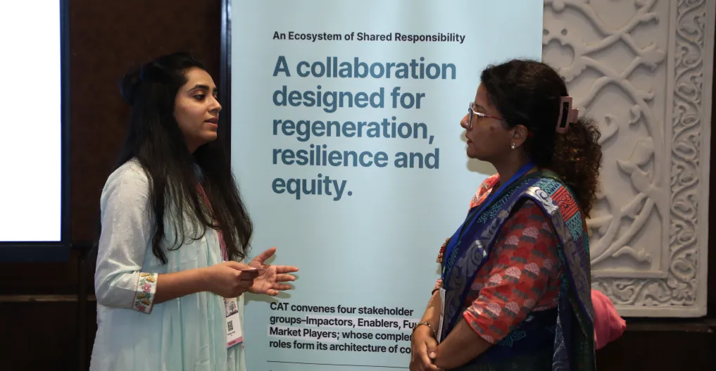 The CAT team interacting with an attendee against a standee.
